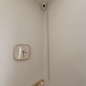 מצלמת אבטחה מותקנת בפינת חדר עם שעון על הקיר