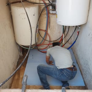 אדם עובד על איטום רצפה עם יריעות בידוד