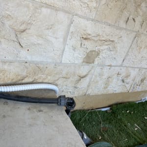 צינור חשמל גמיש ליד קיר אבן