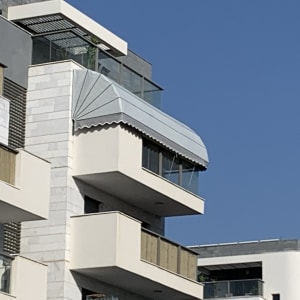 מרפסת עם סוכך מתכת גלי על בניין מודרני