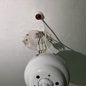 חוטי חשמל צבעוניים מחוברים לתקרה עם נורה אדומה