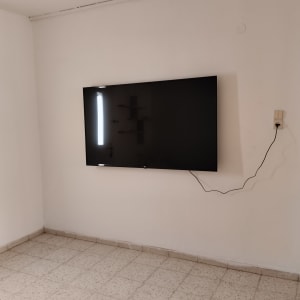 טלוויזיה תלויה על הקיר עם כבל חשמל