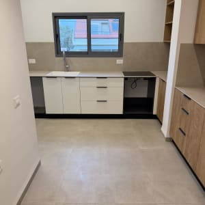 מטבח נקי ומסודר עם ארונות וכיור.