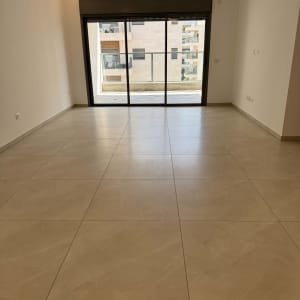 חדר ריק עם רצפת אריחים וחלון גדול