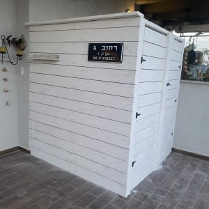 מבנה עץ לבן עם שלט רחוב