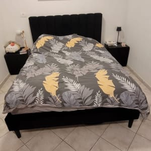 חדר שינה עם מיטה, מצעים ותמונה על הקיר