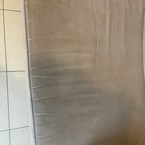 כרית ספה עם כתמים קלים על ריפוד בד בז