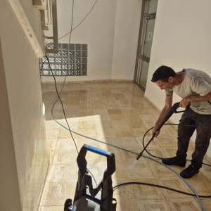 אדם משתמש במכונת שטיפה בלחץ על רצפה