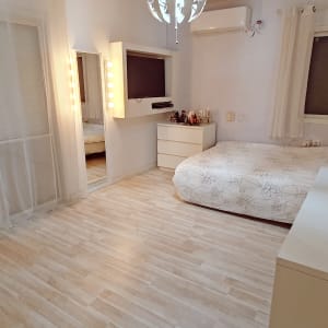 חדר שינה עם מיטה, שידה ומראה מוארת