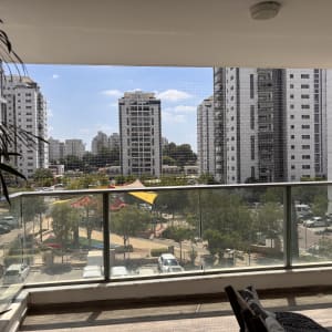 מרפסת עם רשת נגד יונים ונוף עירוני