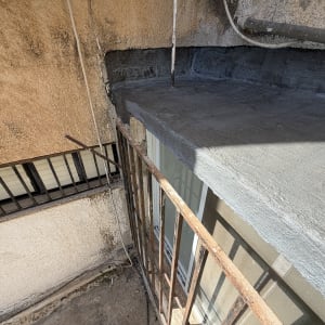 איטום גג עם חומר איטום אפור ליד מעקה ברזל