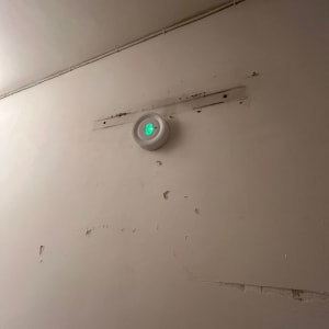 מכשיר עגול עם אור ירוק מותקן על קיר