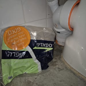 צינור ביוב מתחת לכיור עם שקית חומר ניקוי