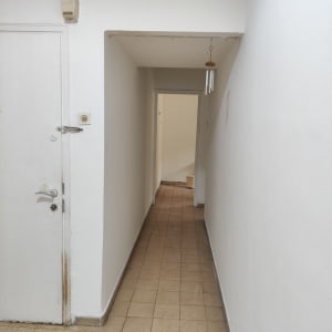 מסדרון עם קירות לבנים ודלת לבנה