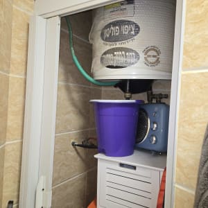 דוד שמש עם צינור ירוק ודלי סגול