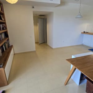 חדר ריק עם מדפים, מנורות ושולחן עץ