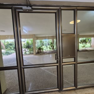 דלת זכוכית עם מסגרת מתכת בכניסה לבניין