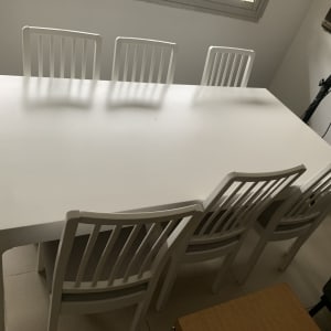 שולחן לבן עם שישה כיסאות לבנים בחדר