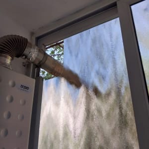 צינור מתכת מחובר לחלון זכוכית מטושטשת