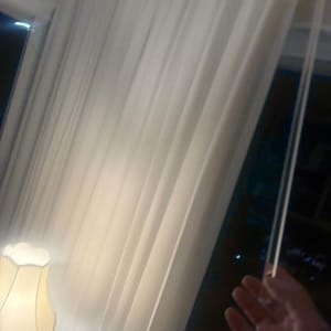 וילון לבן עם מנורת לילה בצד