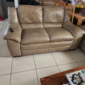 ספה מרופדת עור חום עם שלט על הידית