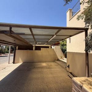 סוכך קבוע ומבנה הצללה ממתכת מעל חניית בית פרטי