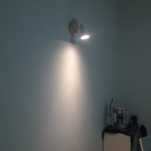 מנורת קיר דולקת על קיר לבן