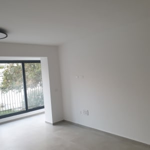 קירות לבנים צבועים בחדר ריק עם חלון גדול