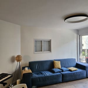 קיר לבן עם סימני צבע, ספה כחולה