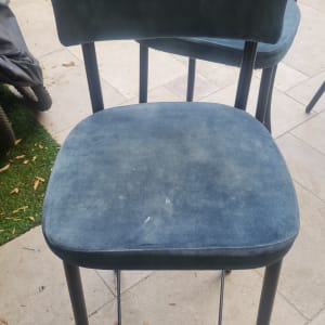כיסא מרופד כחול על רצפת אבן בחוץ