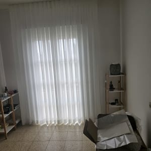 וילון לבן שקוף תלוי על חלון גדול