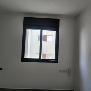 חלון אלומיניום עם מסגרת שחורה בקיר לבן