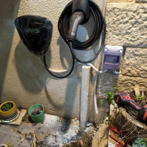 מטען לרכב חשמלי עם כבל תלוי על קיר