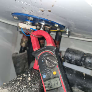 מד מתח מחובר לחוטים חשמליים במערכת חימום