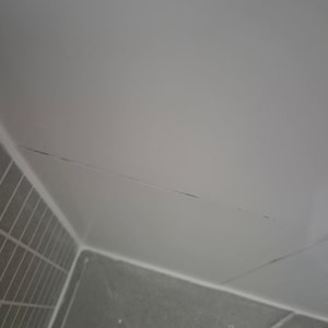 סדק בקיר אריחים בפינת חדר אמבטיה