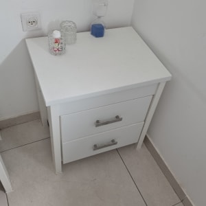 שידה לבנה עם חפצים עליונים בפינה