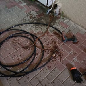 כבל שחור, כפפה שחורה, מקדחה על רצפה רטובה