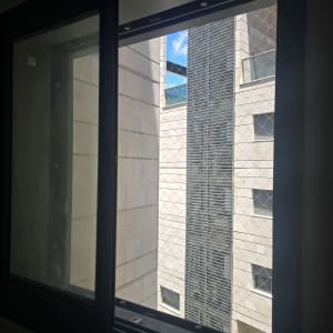 חלון עם רשת נגד יונים בבניין מגורים