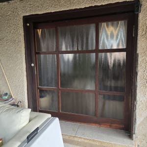 דלת זכוכית עם מסגרת עץ במרפסת חיצונית