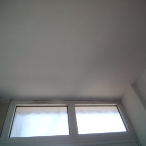 תקרה צבועה בלבן מעל חלון עם מסגרת לבנה