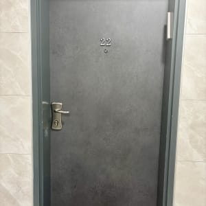 ציפוי דלת כניסה לדירה בטפט אפור במרקם דמוי בטון