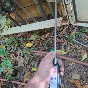 יד מחזיקה מכשיר איתור נזילות ליד צינורות.