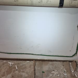 חוטי חשמל מותקנים בקיר עם פסולת בנייה על הרצפה