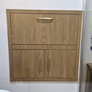 ארון עץ עם ידיות מתכת בחדר אמבטיה