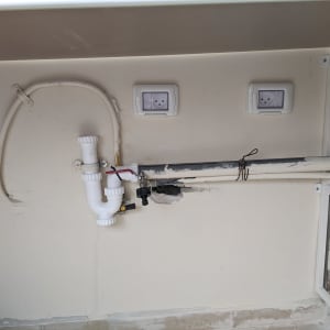 צנרת פלסטיק לבנה עם חיבורים מתחת לכיור