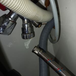 צינורות מתכת ופלסטיק מתחת לכיור