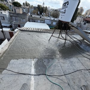 גג עם איטום בטון ומיכל מים על הגג