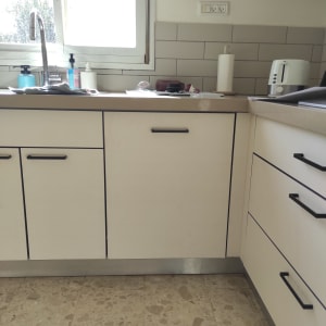 מטבח עם ארונות כיור וכלים על השיש