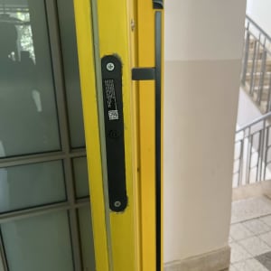 מנעול מותקן על דלת צהובה עם ידית מתכת.
