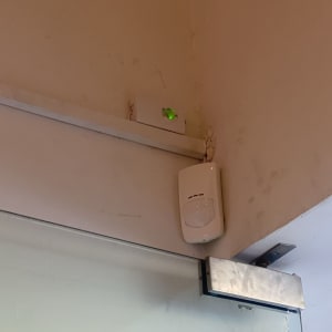 חיישן תנועה מותקן על קיר ליד דלת זכוכית